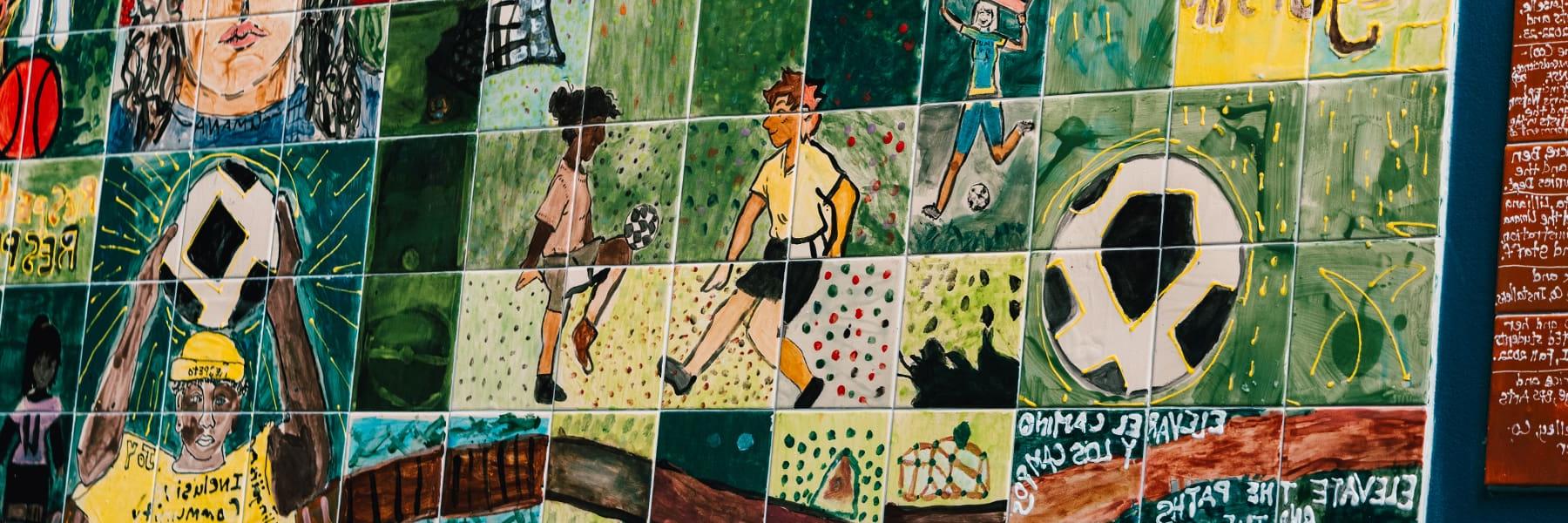 Mural of young people playing soccer in Boston.